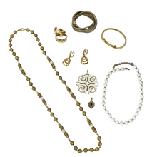 Load image into Gallery viewer, Vintage Jewelry Grab Bag includes 1 pair of gold clip on Trifari earrings, 1 pair of gold plate/white enamel hoop earrings, 1 white and gold Trifari pendant, 1 small round silver and gold tone pendant, 1 Monet white and gold bead necklace, 1 long gold tone and faux pearl beaded necklace and 2 gold tone bracelets. 
