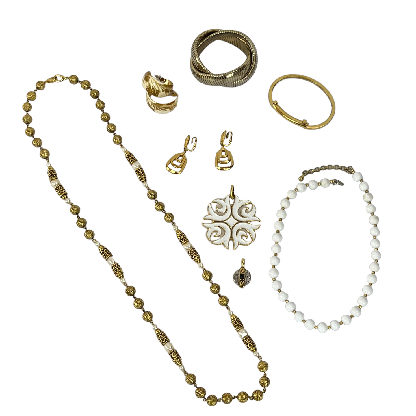 Vintage Jewelry Grab Bag includes 1 pair of gold clip on Trifari earrings, 1 pair of gold plate/white enamel hoop earrings, 1 white and gold Trifari pendant, 1 small round silver and gold tone pendant, 1 Monet white and gold bead necklace, 1 long gold tone and faux pearl beaded necklace and 2 gold tone bracelets. 