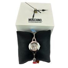 Load image into Gallery viewer, Moschino Charm Chain Watch, featuring &quot;Tea Time&quot; charms. Stamped 60389. Water resistant. Comes in it&#39;s original Hours &amp; Minutes clock box on a black leather pillow. Features 7 charms including the Moschino logo. 90s Moschino watch chain charm bracelet. Vintage Moschino.  Very good vintage condition. The box clock has not been tested. The watch needs a battery.     Processed within 1 business day (not included in shipping carrier’s estimated arrival time). Tracking uploaded immediately upon shipment.
